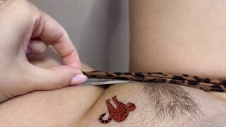 Tattoo master in leopard panty doing temporary tattoo