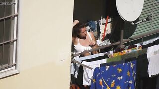 Busty girl enjoying the sun on the balcony