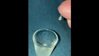 Closeup dripping cum in shot glass slo-mo