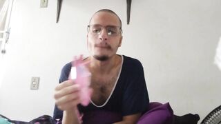 bald man eating pink fini candy