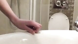 Girl with a very hairy pussy put her leg on the washbasin and pissing in it