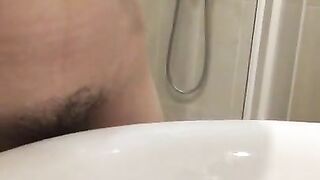 Girl with a very hairy pussy put her leg on the washbasin and pissing in it