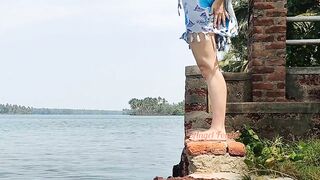 Shameless tourist girl pissing on the public waterfront taking off her swimsuit.