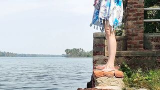 Shameless tourist girl pissing on the public waterfront taking off her swimsuit.