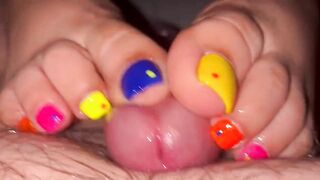 Tickling teasing colourful neon toes rubbing on a big head