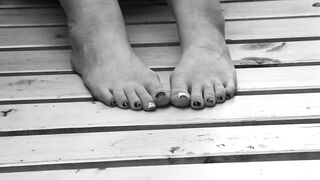 Women's feet on a park bench.