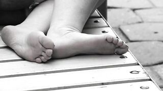 Women's feet on a park bench.