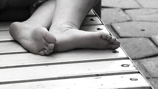 Women's feet on a park bench.