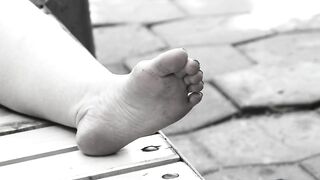 Women's feet on a park bench.